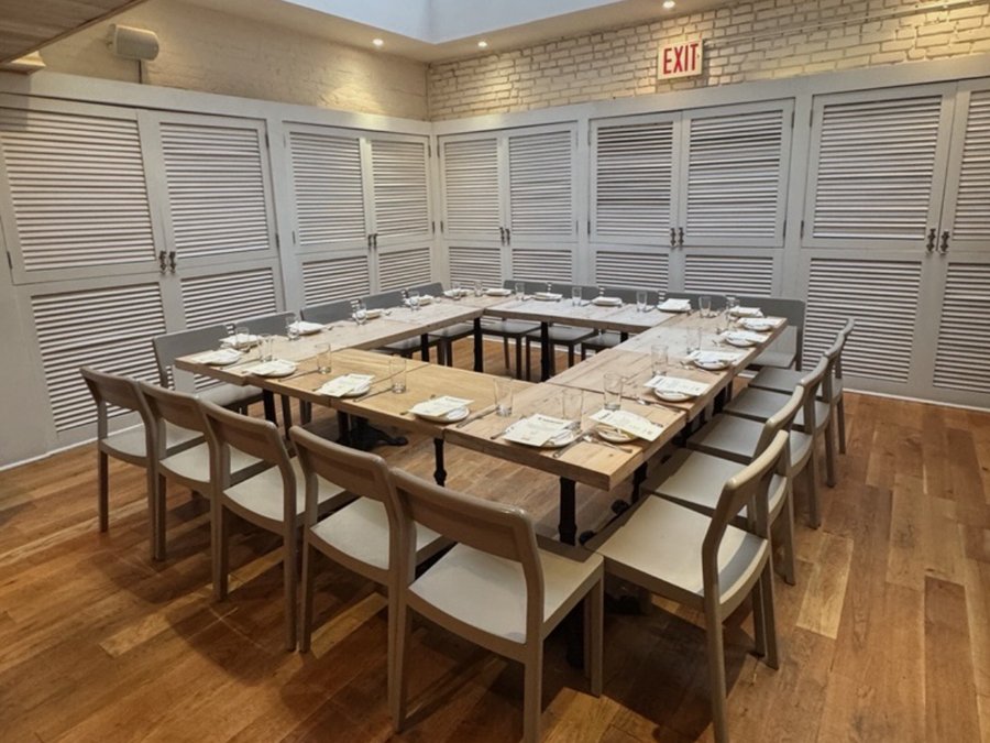 Private dining room with a square table set for a group breakfast under a skylight