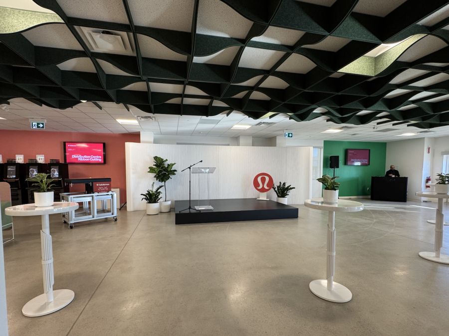 Ribbon-cutting event space with stage, plants and cocktail tables